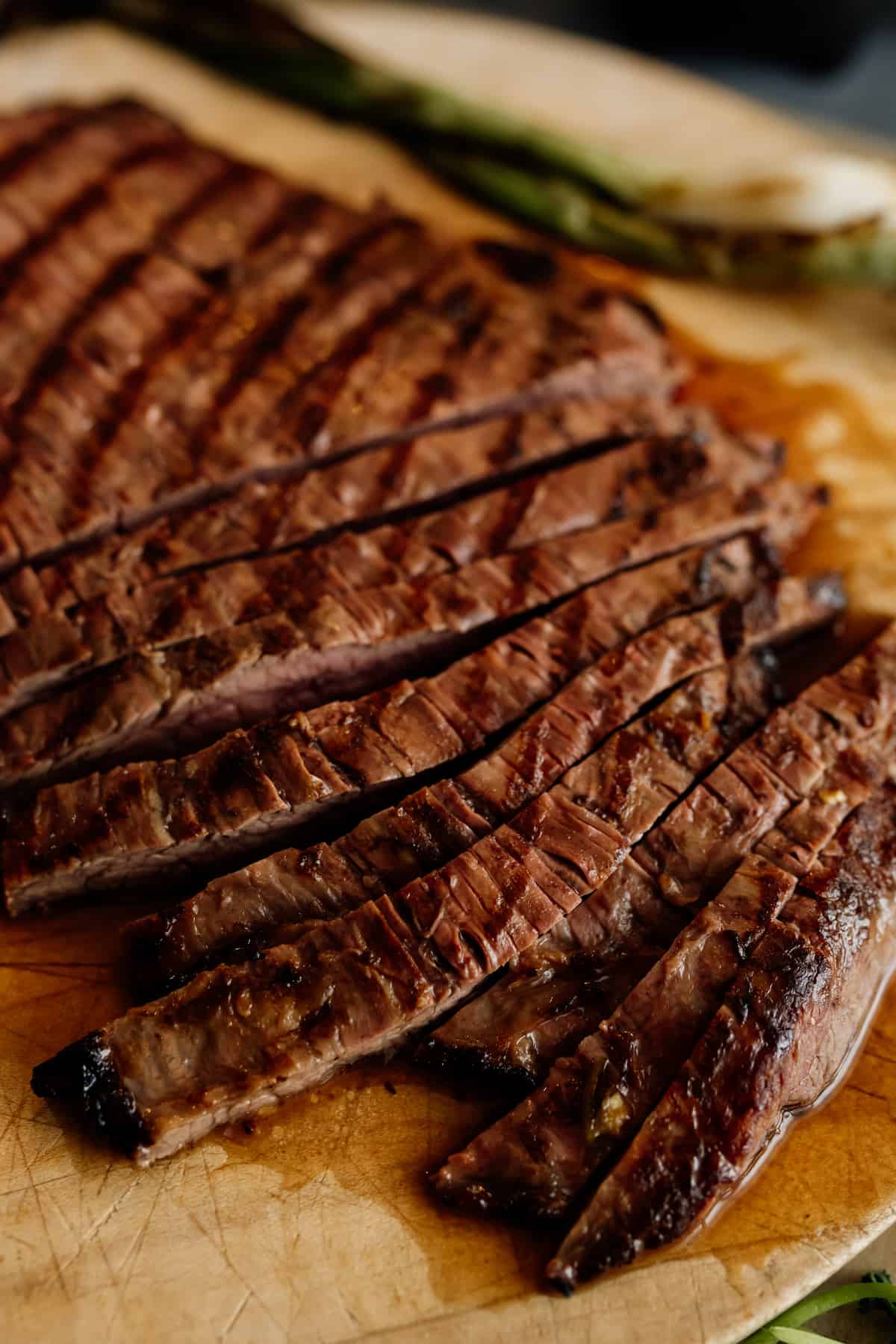 carne asada flank steak on a cutting board being sliced