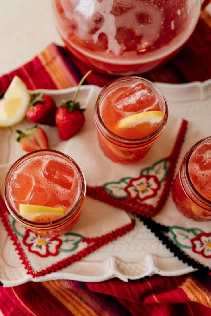 close up shot of strawberry sweet tea in a mason jar garnished with a fresh lemon slice