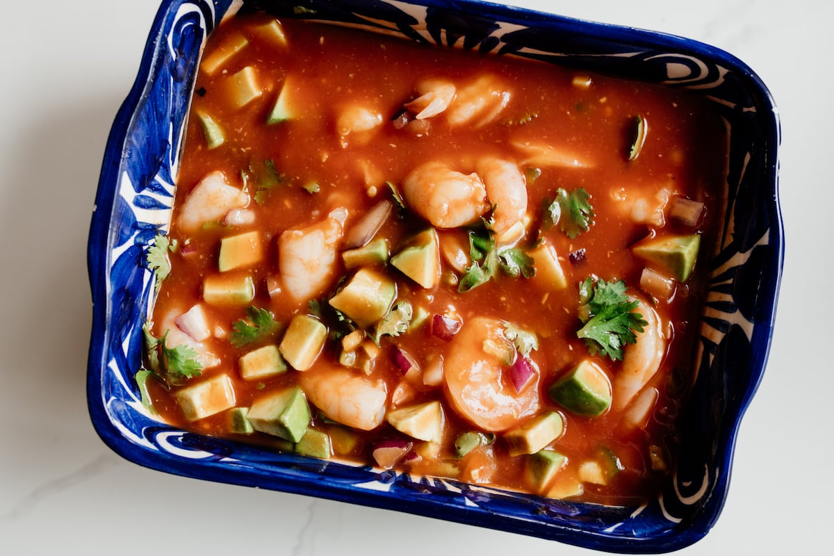 completed coctel de camarones (Mexican shrimp cocktail) in a rectangular blue serving bowl for serving family style.