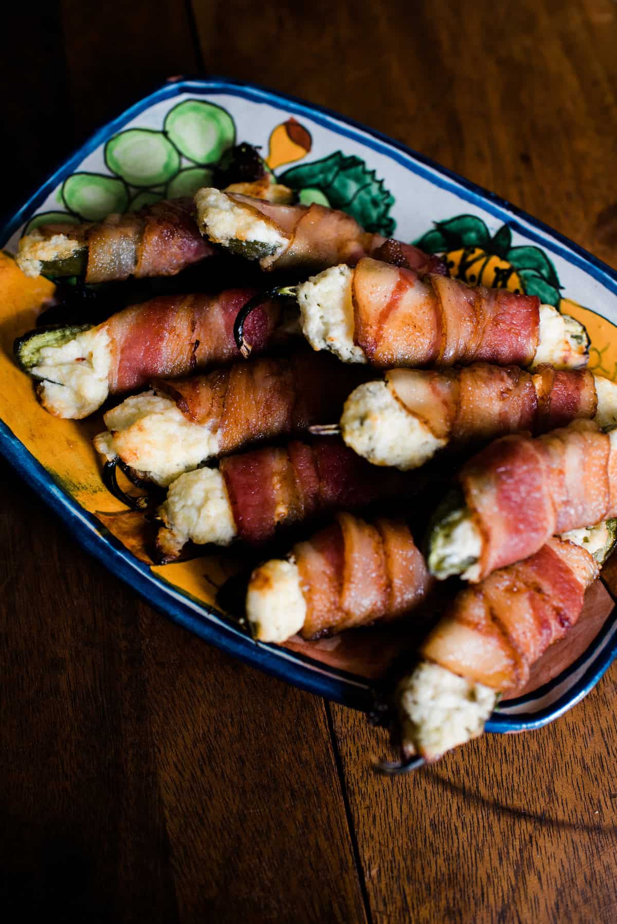 Bacon-wrapped jalapeño poppers served on a vibrant, colorful platter, ready to enjoy