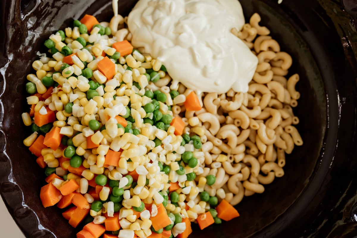 cooked veggies, yogurt, mayo, and seasoning added to bowl with cooked macaroni.