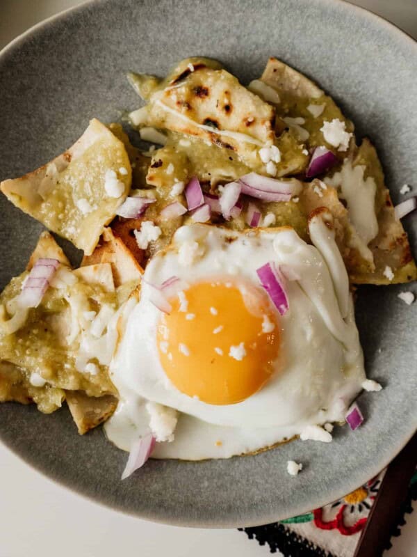 chilaquiles verders on a gray plate with a fried egg on top