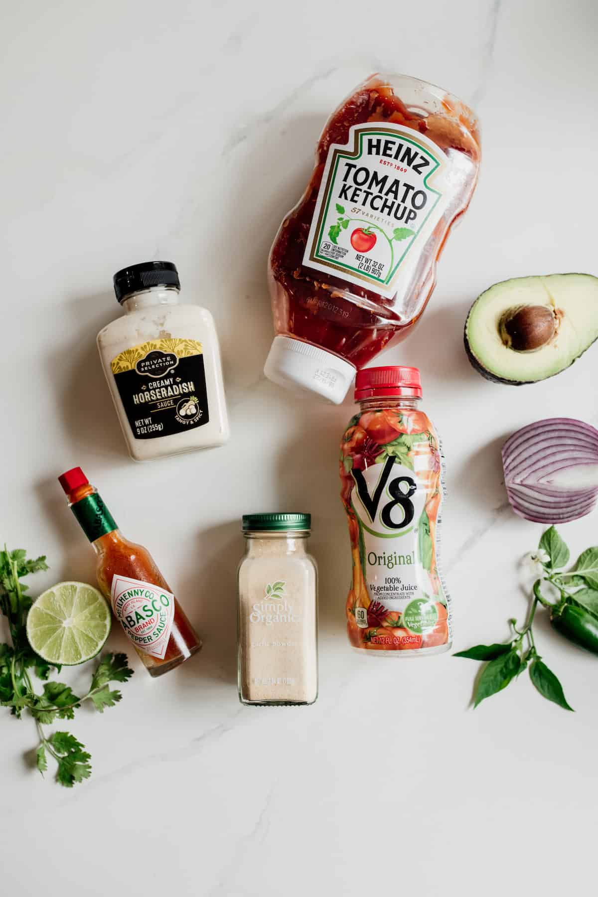 ingredients to make mexican shrimp cocktails laid out on a white table.