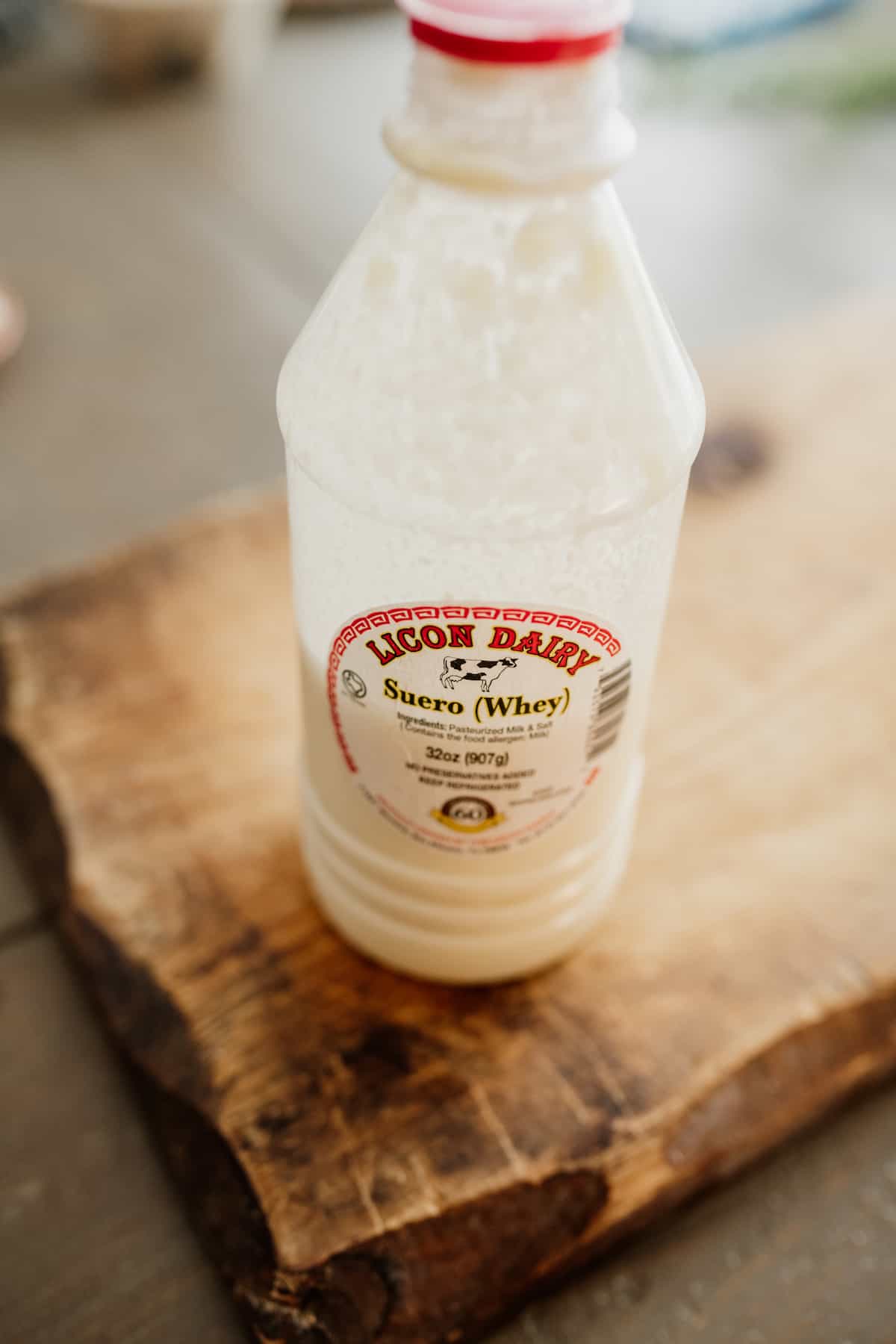 plastic bottle of suero (whey) from Lincon Dairy in El Paso San Eli Texas on a wooden board