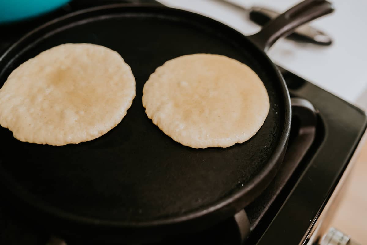two Sweet Gorditas on a cast iron griddle cooking