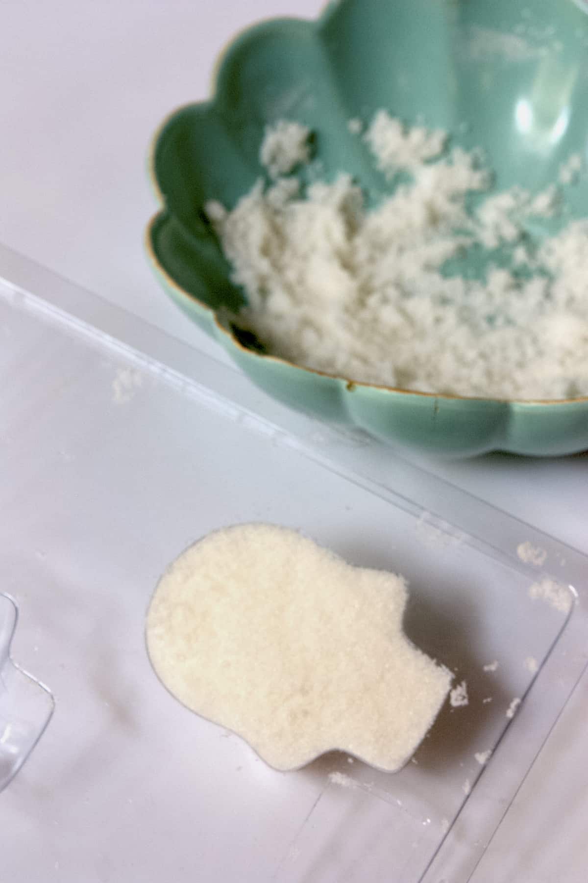 the sugar mixture for creating these Day of the Dead sugar skulls in a plastic skull mold