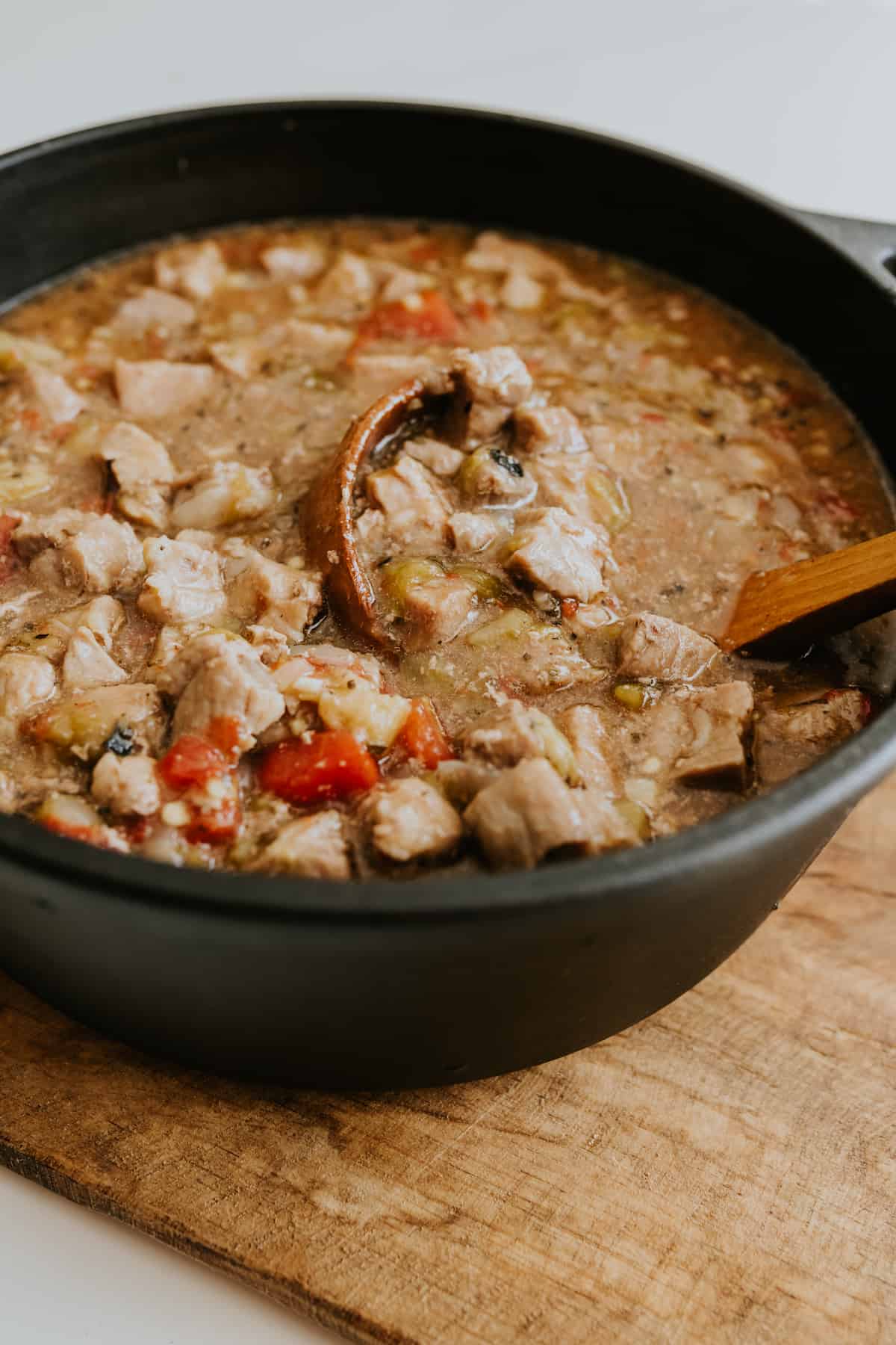 Pork Green Chile in a black cast iron pot packed with peeled, roasted chiles and succulent pork to create an easy and warming stew