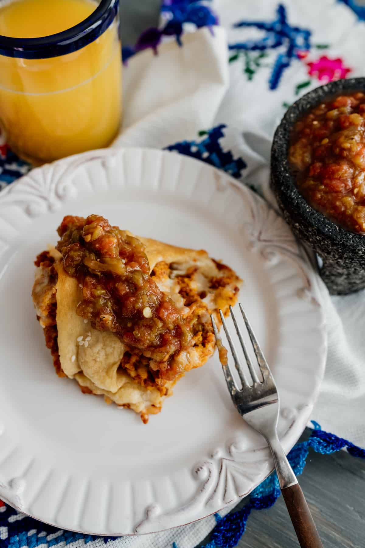 slice of crescent breakfast ring topped with homemade salsa and a side of salsa and orange juice