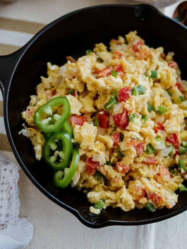 Huevos a la Mexicana, Mexican-style scrambled eggs in a cast iron skillet garnished with jalapeño slices