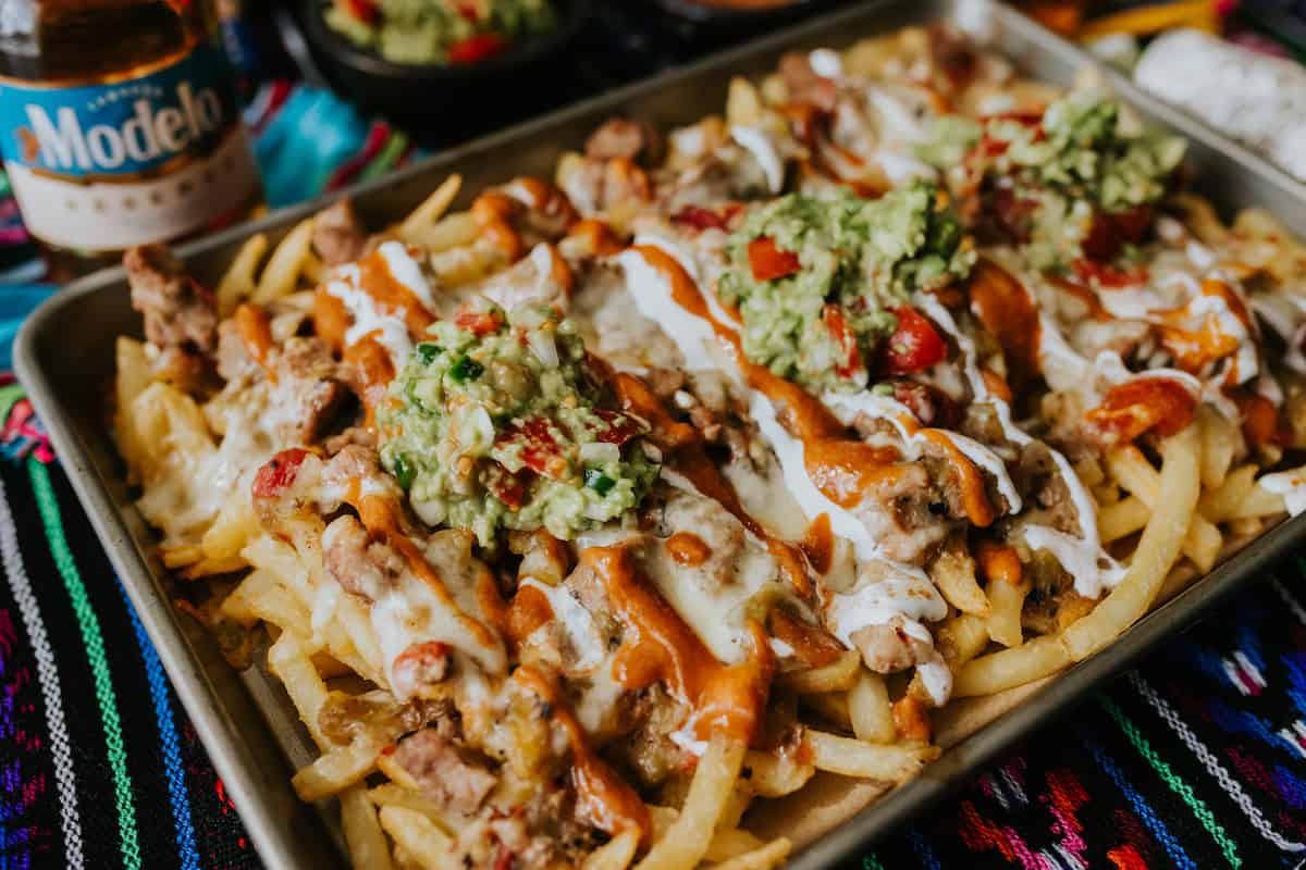Pork Green Chile Loaded Nacho Fries with guacamole and sour cream