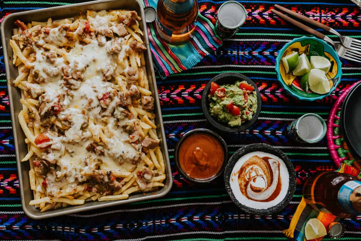 Pork Green Chile Loaded Nacho Fries with bowls of toppings