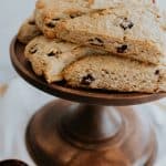 Stack of Cranberry Maple Oatmeal Scones on a wooden cake pedestal, showing their golden brown tops and rustic texture.