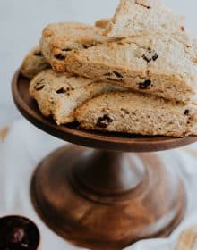 Cranberry Maple Oatmeal Scones stacked on a wooden cake pedestal.