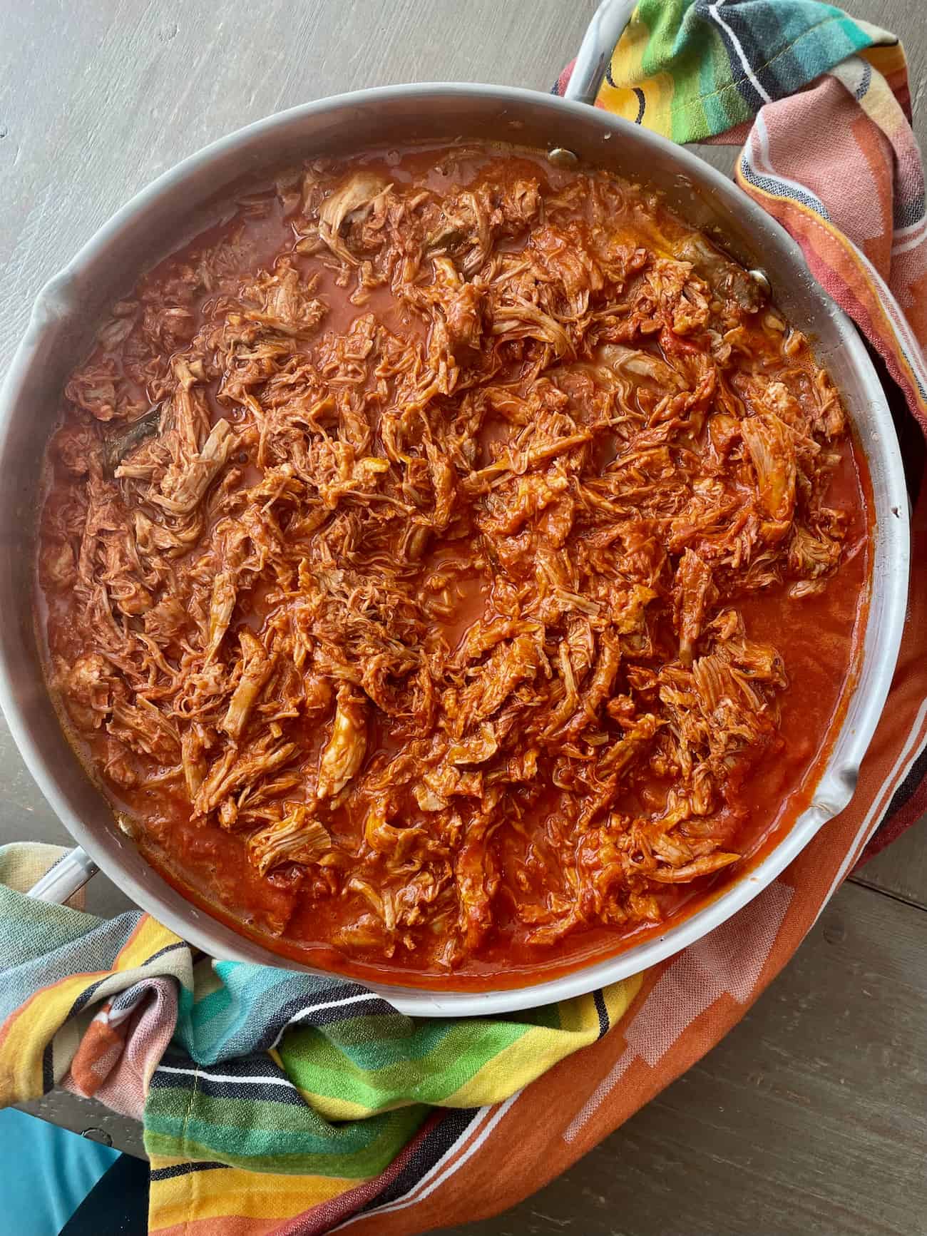 large pan of shredded pork with red chile sauce for stuffing authentic mexican tamales.