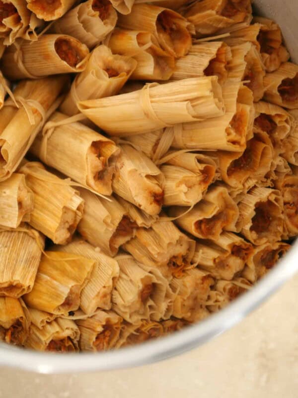 authentic mexican pork tamales rojos steaming in a tamalada.