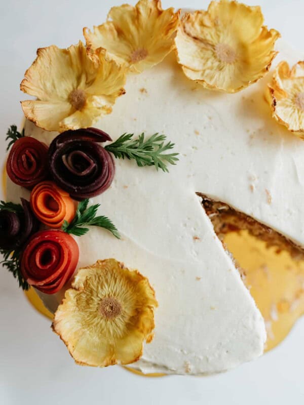 overhead shot of carrot cake decorated with dried pineapple flowers.