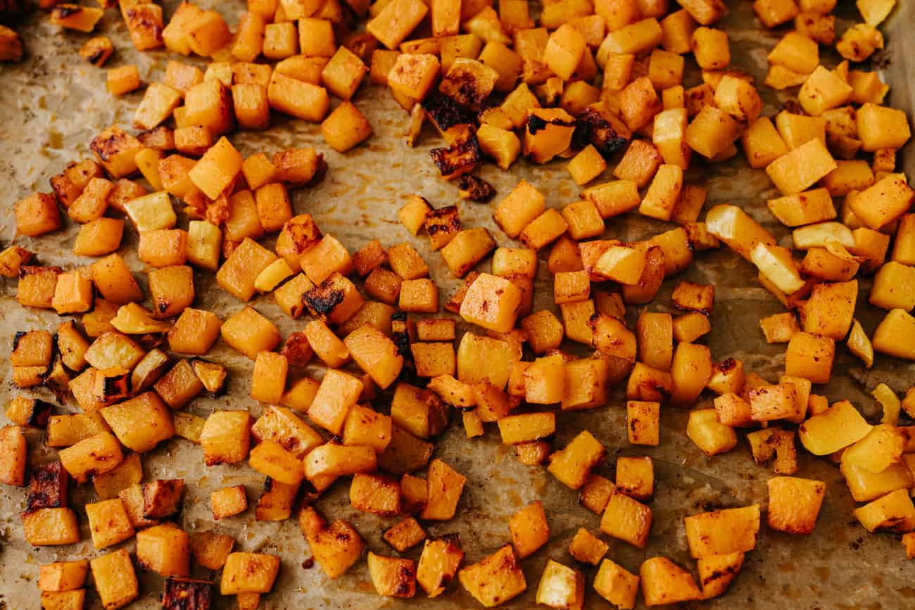 cubes of sheet pan roasted butternut squash with char marks after coming out of the oven.