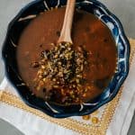 salsa macha in a blue bowl with a wooden spoon.