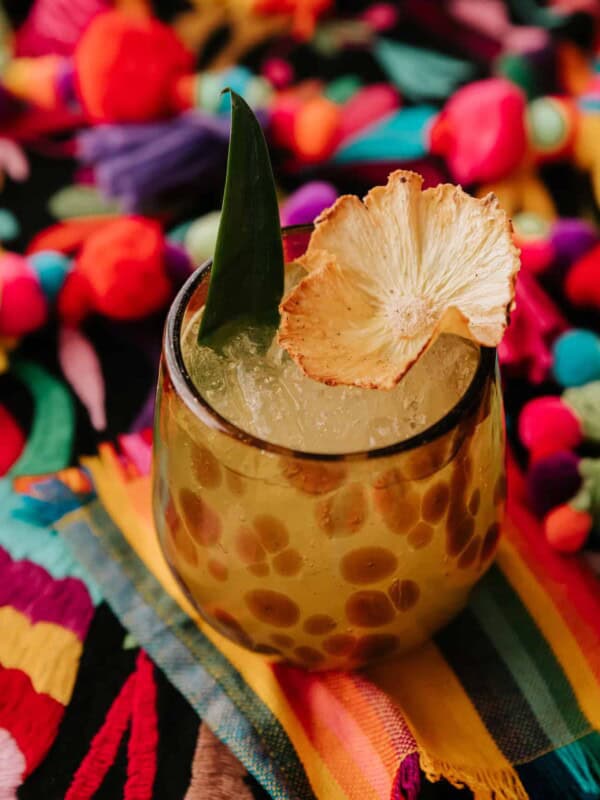 giraffe speckled glass filled with flor de piña cocktail.