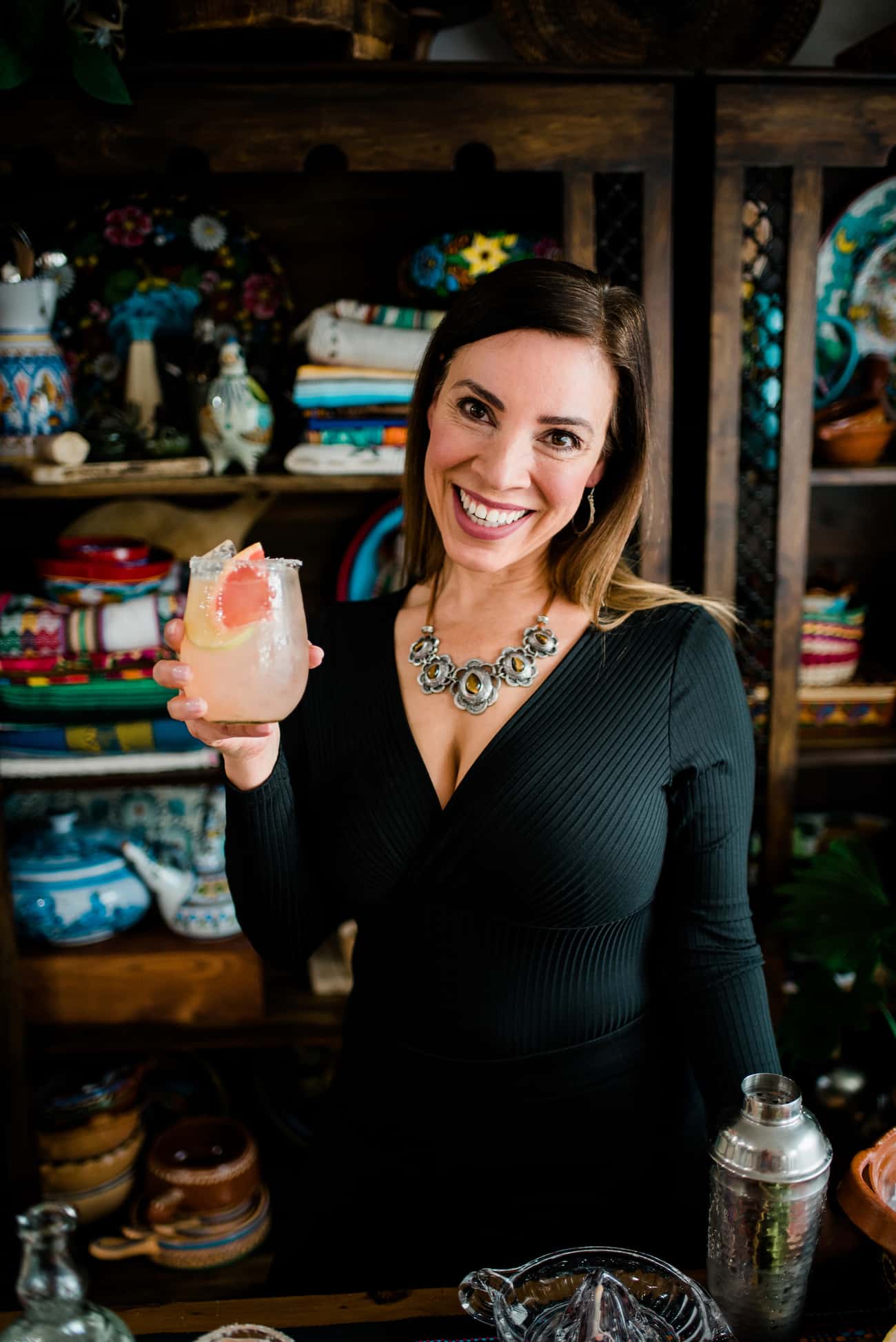 Latina food blogger holding a grapefruit margarita.