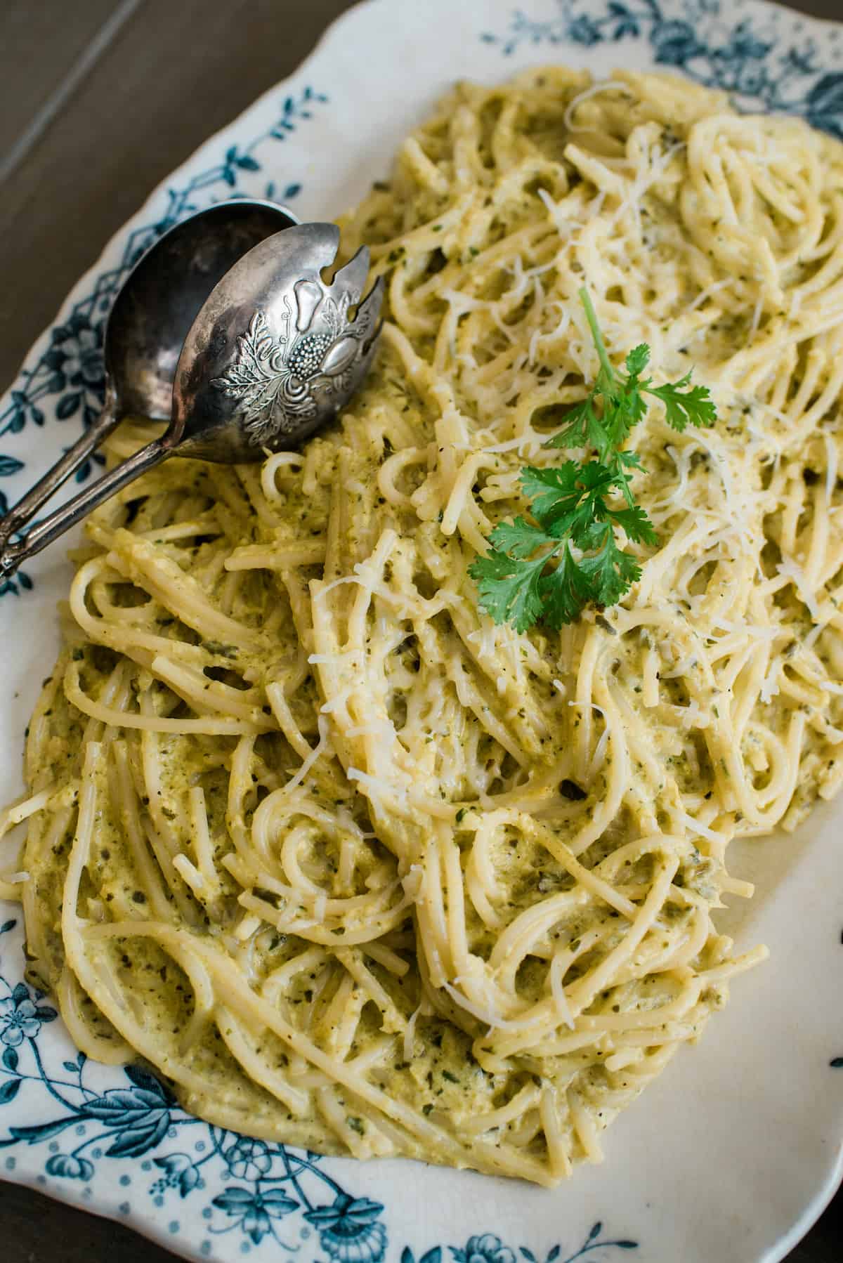 vintage platter and silver tongs with creamy and spicy green spaghetti with poblano cream sauce.
