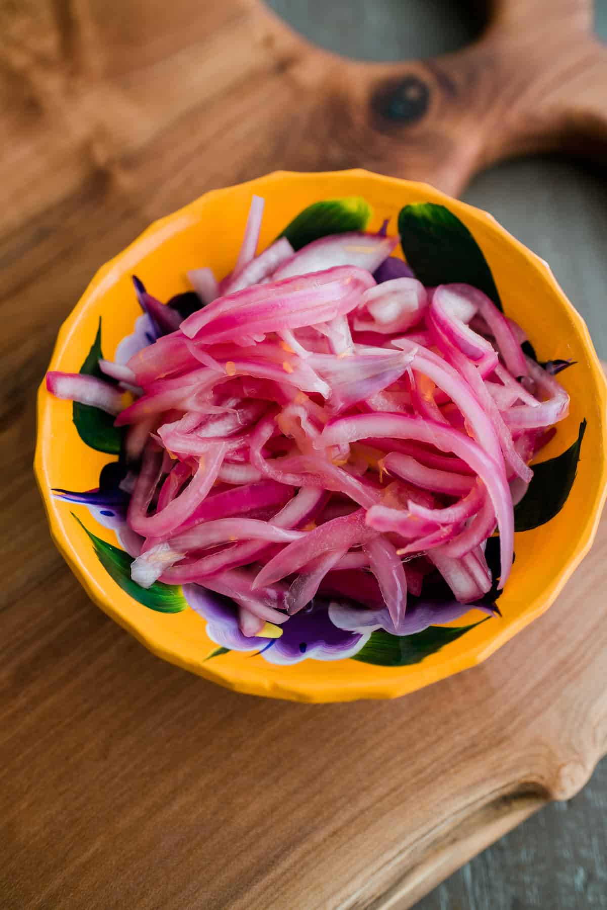 Yellow hand painted bowl filled with Mexican pickled red onions.