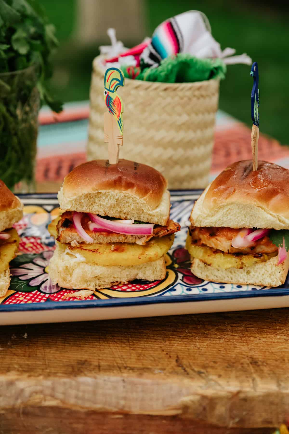 3 mexican pork chop sliders on a hand-painted rectangular serving tray.