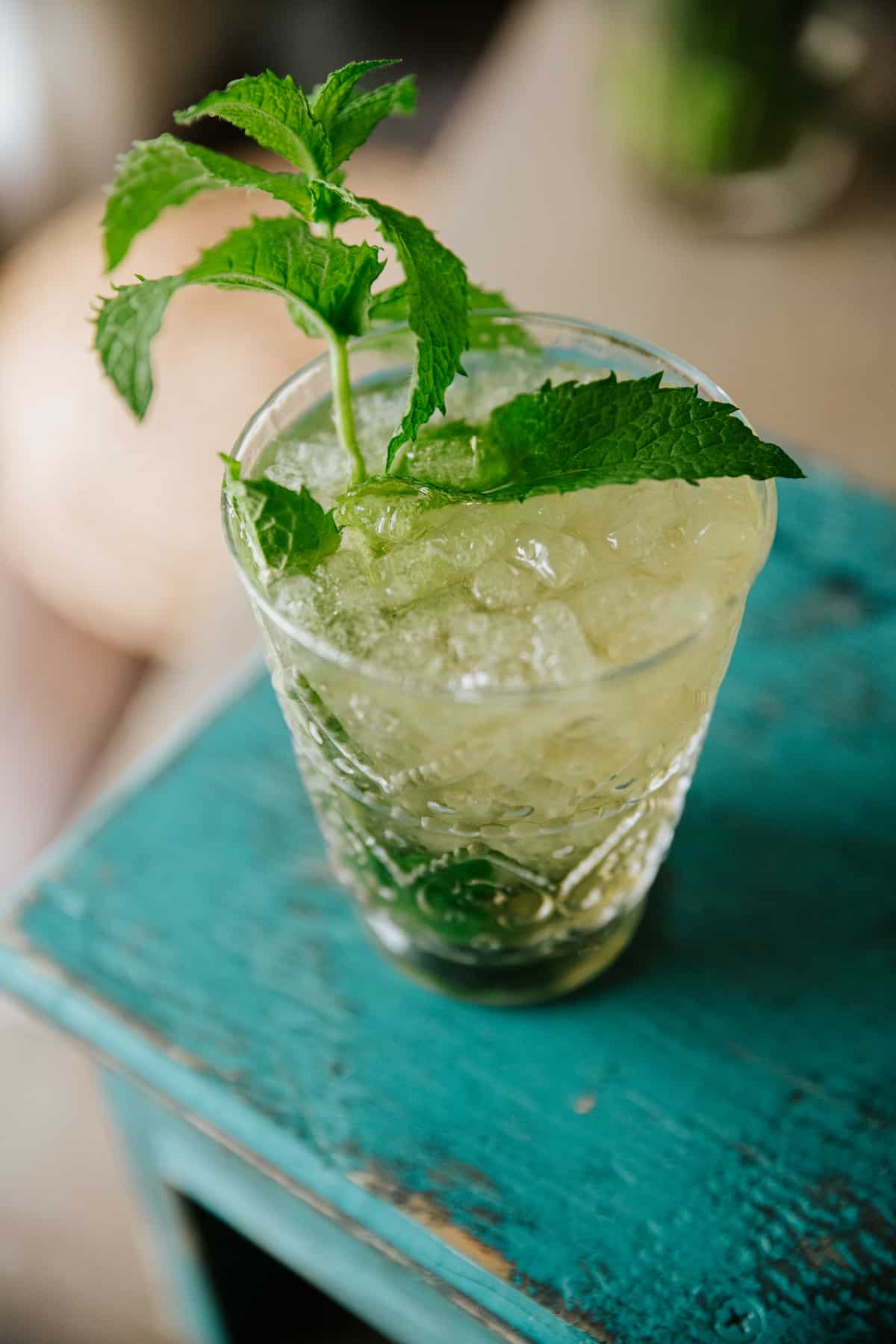 45 degree angle shot of classic mint julep in a clear glass cup with pellet style ice. 