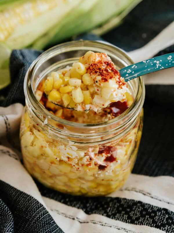 mexican street corn in a mason jar with turquoise spoon.