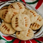 silver serving platter of cajeta peanut butter cookies on a red and green tablecloth.