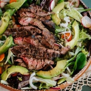 closeup shot of carne asada salad in a terracotta serving bowl.