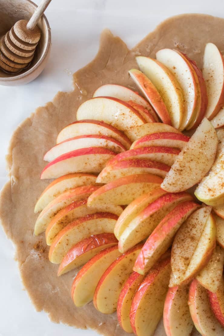 Apple slices sprinkled with cinnamon sugar before baking apple galette.