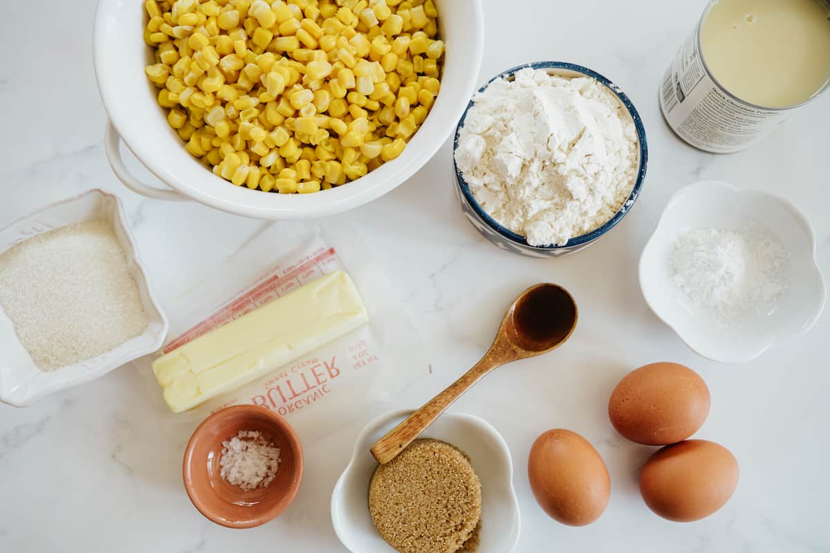 ingredients needed for making mexican corn cake (pan de elote) on a white table.