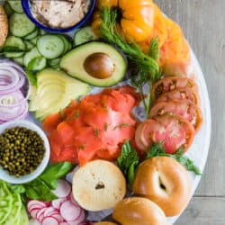 overhead shot of an assembled smoked salmon bagel bar replete with lox, schmear, and veggies.