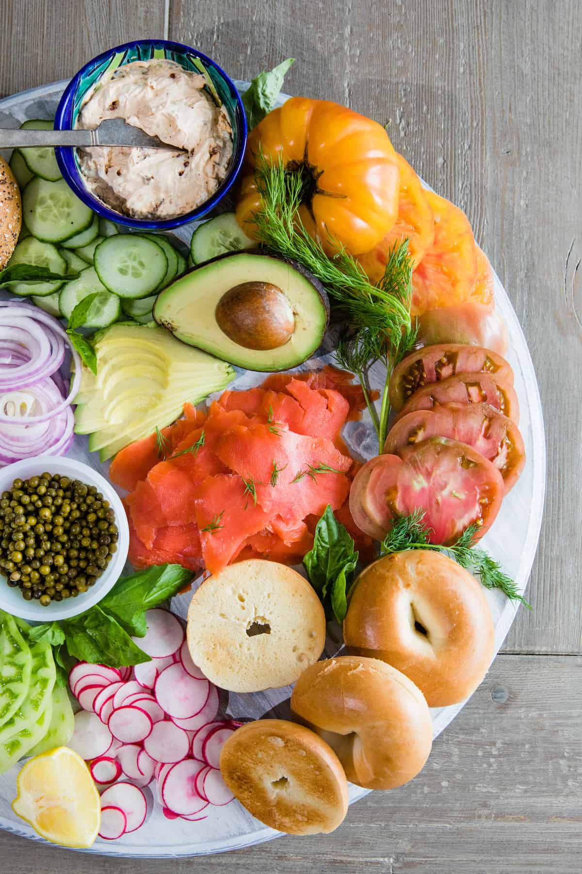 overhead shot of an assembled smoked salmon bagel bar replete with lox, schmear, and veggies.