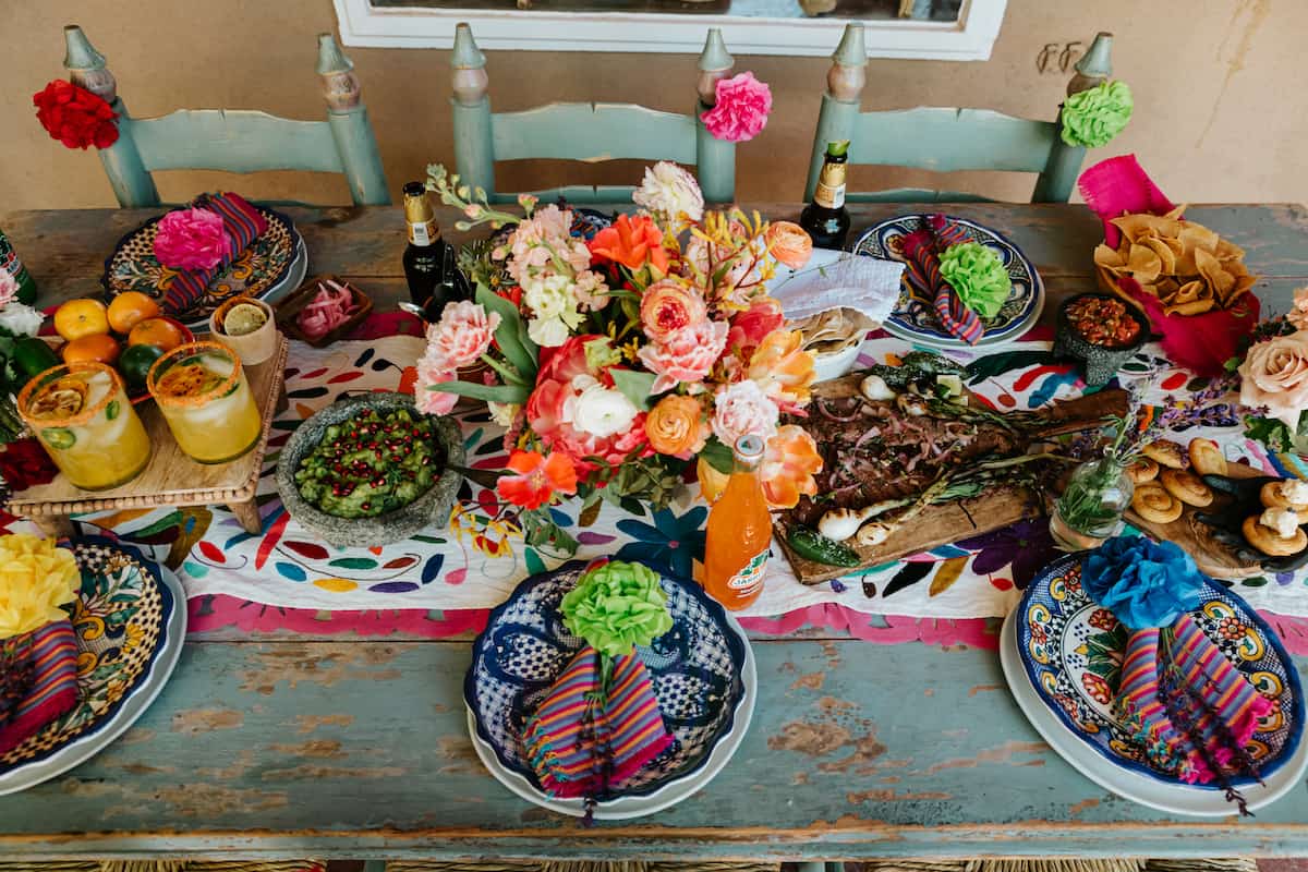 table-lined filled with assorted cinco de mayo drinks, appetizers, entrees, side dishes, snacks, and crafts.