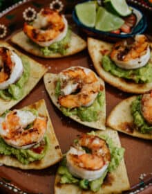 Easy Grilled BBQ Shrimp Appetizer with Baked Flour Tortilla Chips and guacamole on a terracotta plate.