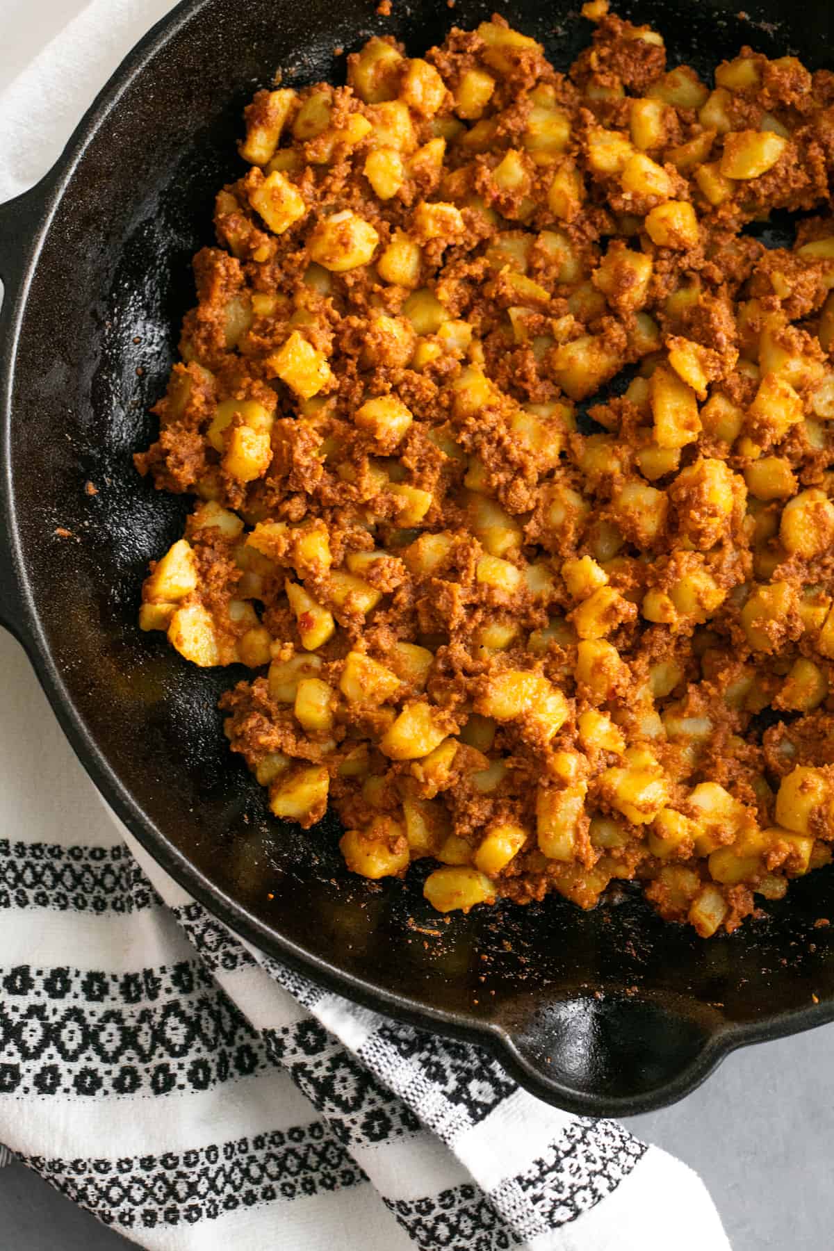 Overhead shot of papas con chorizo in a black skillet.