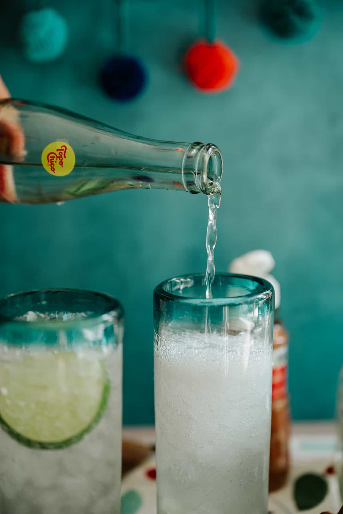 action shot of pouring sparkling mineral water into the glass to complete the ranch water cocktail.