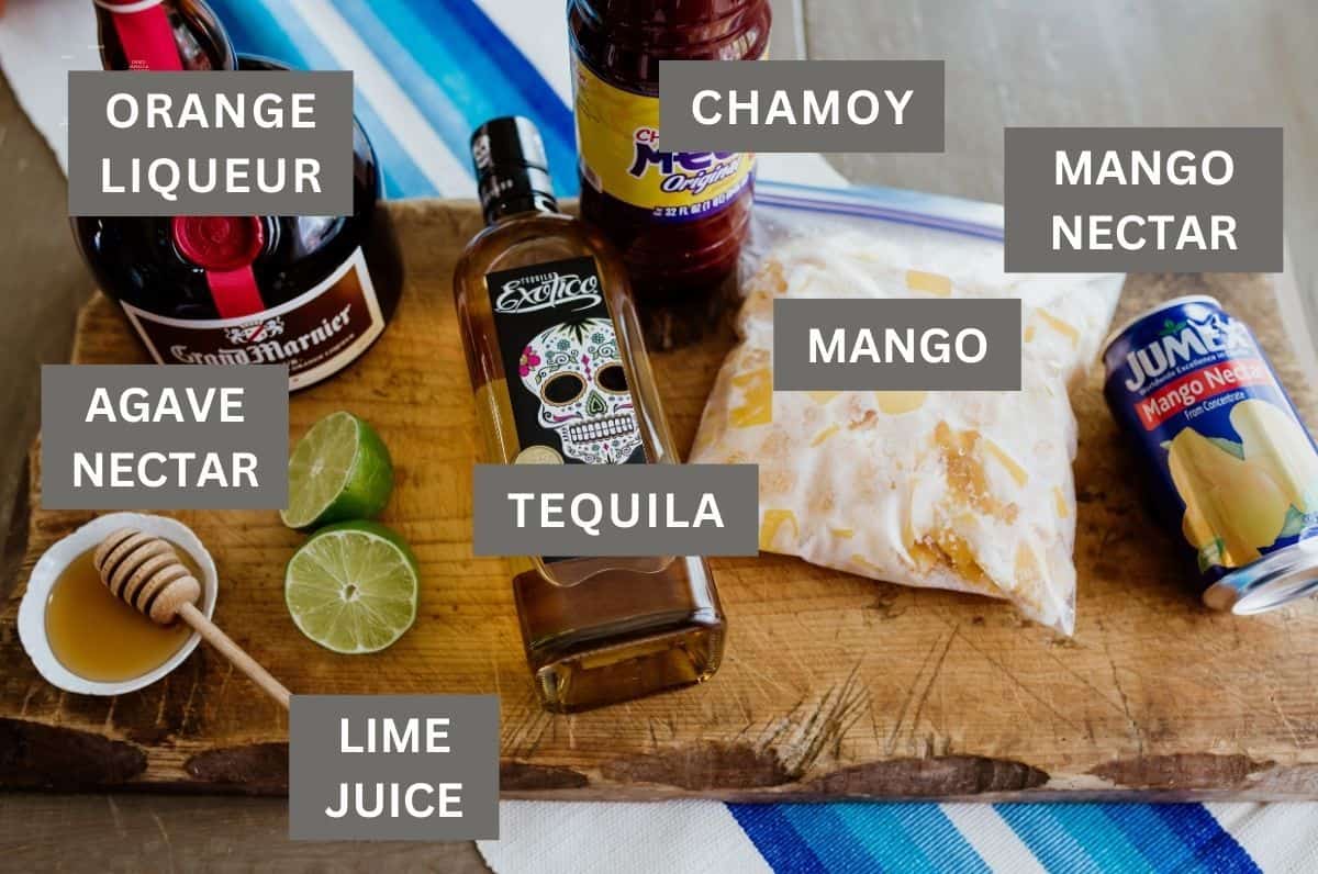 ingredients needed to make Frozen Mangonada margaritas measured out on a wooden cutting board. 