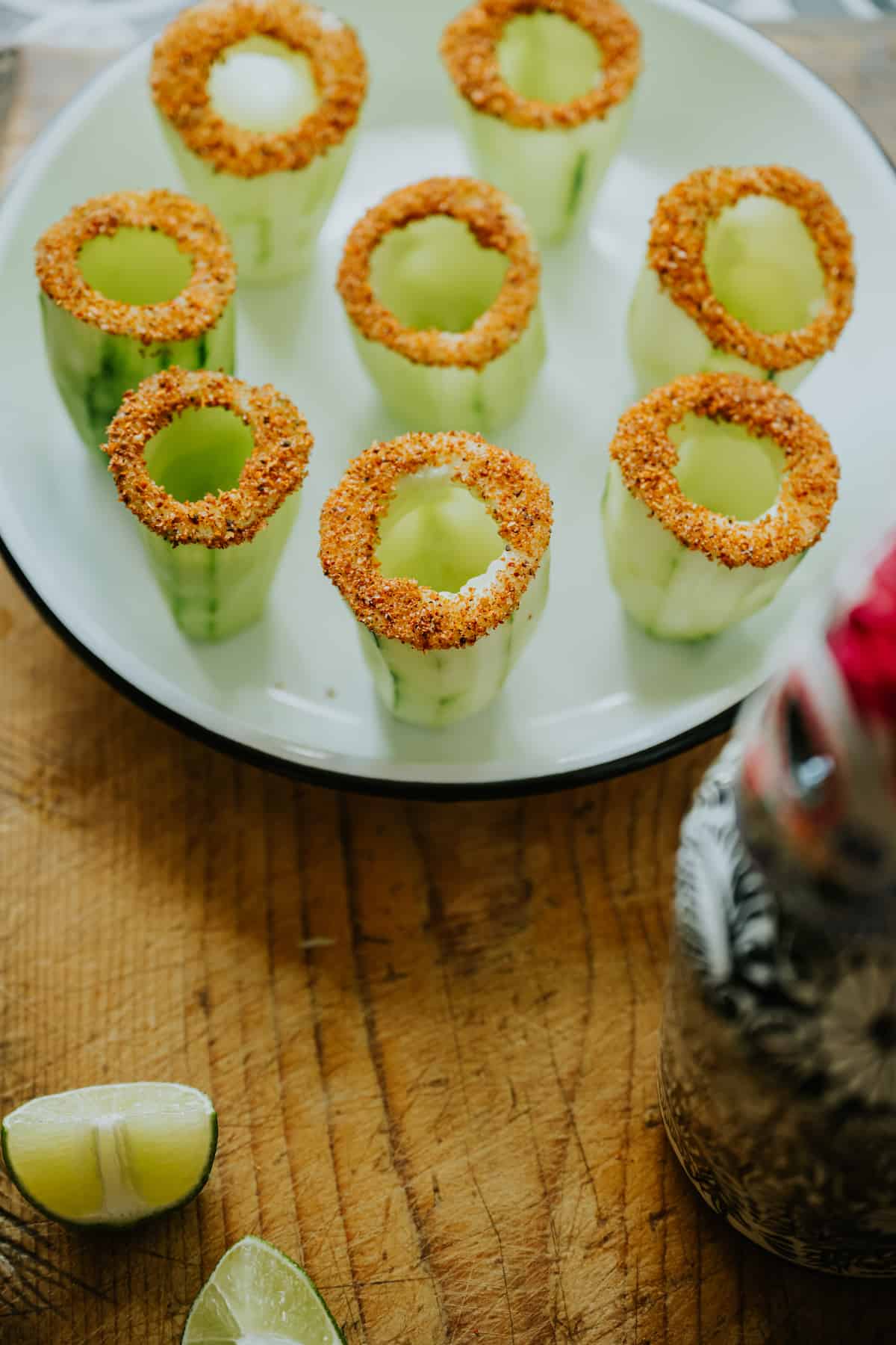 cucumber shot glasses that have been dipped in tajin to rim.