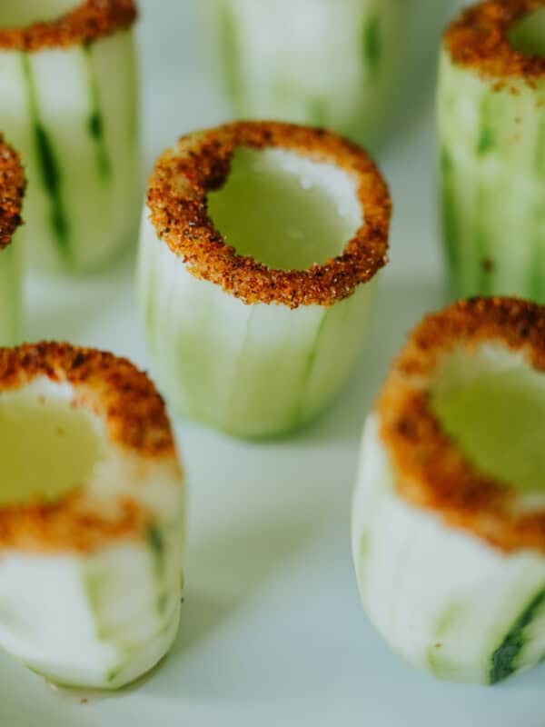 tajin rimmed cucumber shot glasses filled with tequila-spiked agua de pepino.