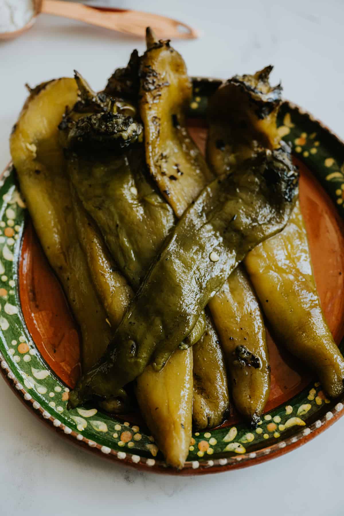 closeup shot of a plate with roasted and peeled hatch green chiles. 