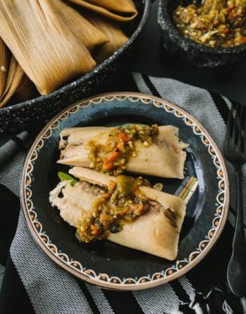 Instant Pot Tamales with Pork and Roasted Green Chile plated on a black plate.