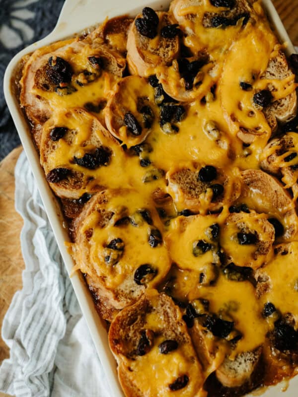 flat lay shot of a 9x13 filled with cheesy capirotada (mexican bread pudding) on a wooden table.