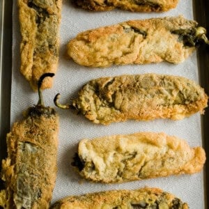 homemade chile rellenos on a paper towel lined baking sheet.