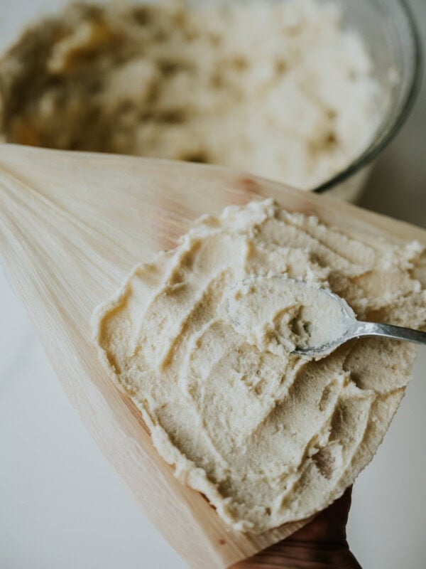 hero shot of masa harina tamales being assembled in corn husks.