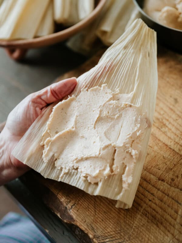 soaked hoja corn husk spread with a layer of masa para tamales.