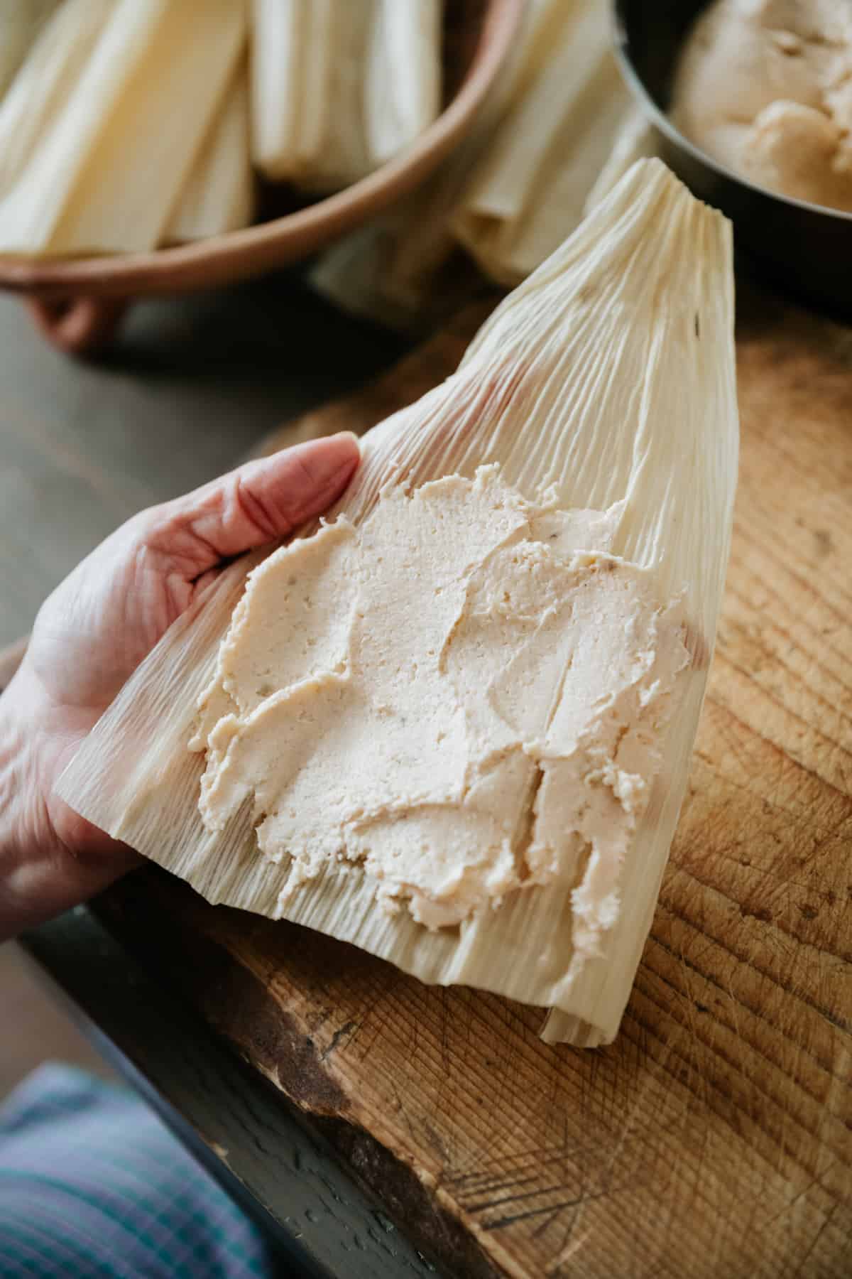soaked hoja corn husk spread with a layer of masa para tamales. 