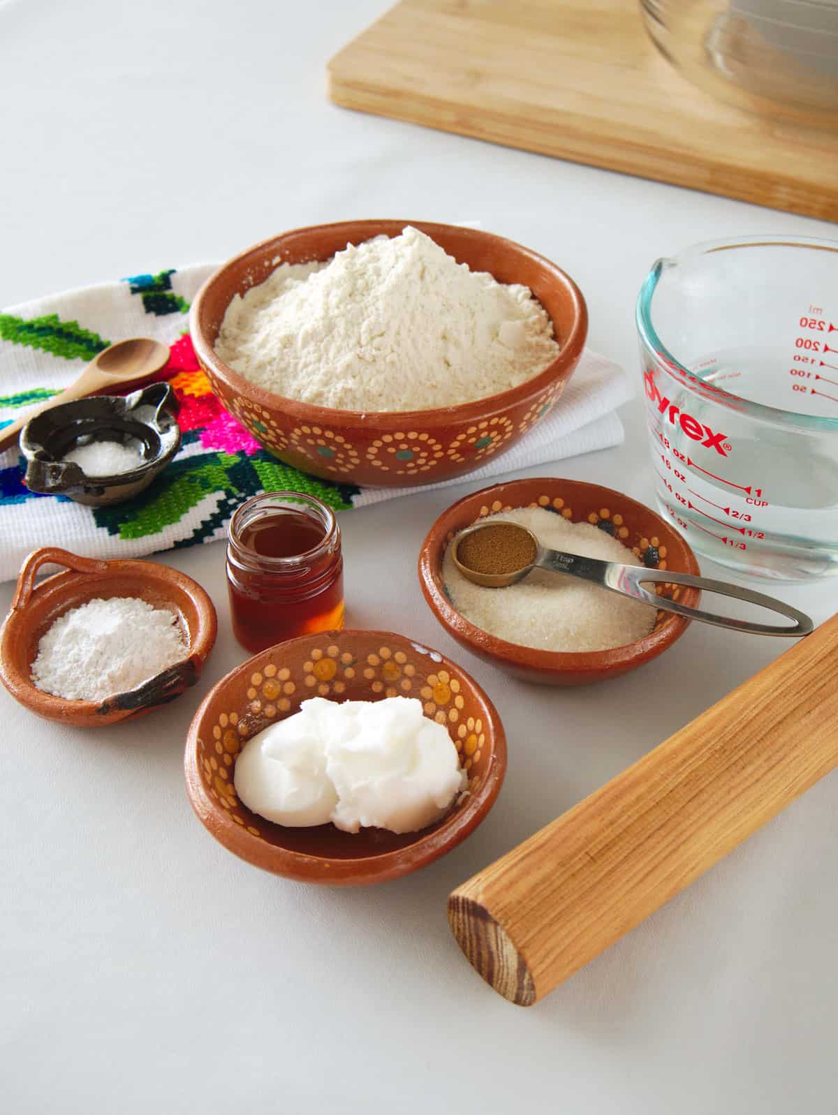 ingredients needed to make basic sopapillas meaured out into bowls on a white table. 